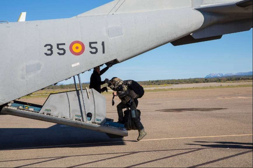 Debido al pesado equipamiento, el paracaidista es ayudado a subir a la plataforma de salto, un CASA C-295 del Ala 35