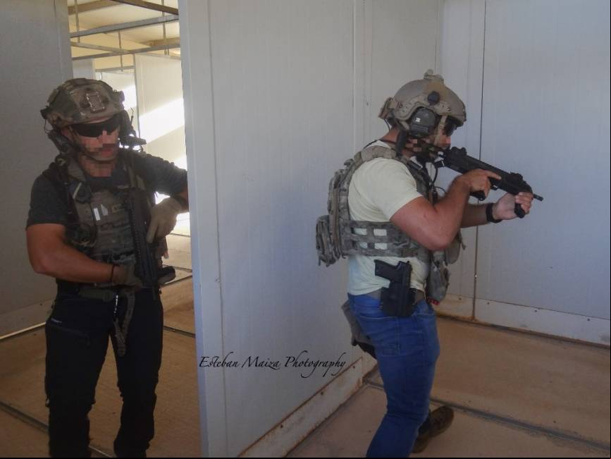 Dos operadores de un equipo especializado en operar en zona gris con vestimenta de civil limpiando una habitaci