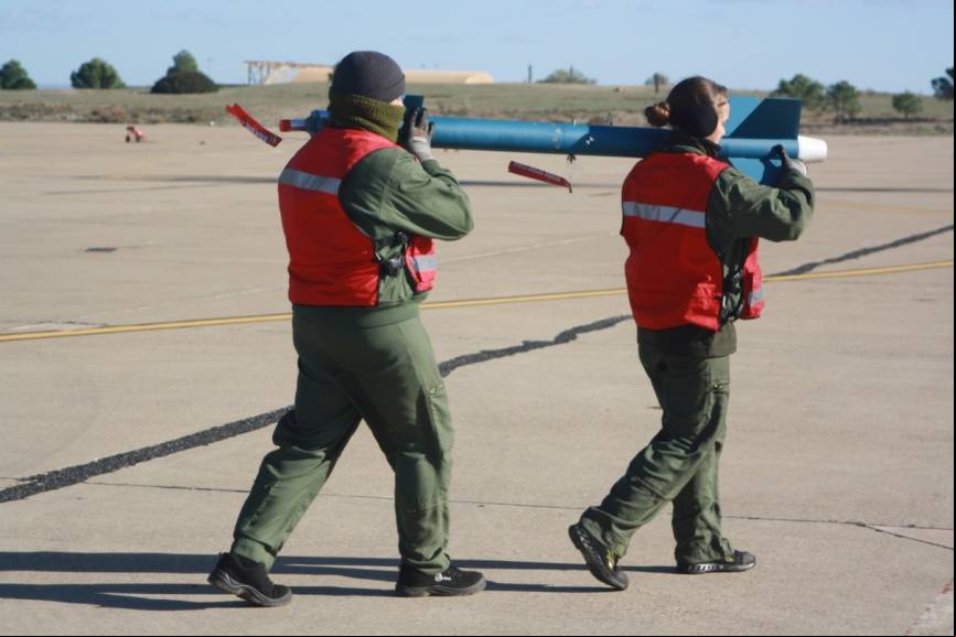 Dos armeros de la Novena Escuadrilla portando un misil de entrenamiento LGTR.